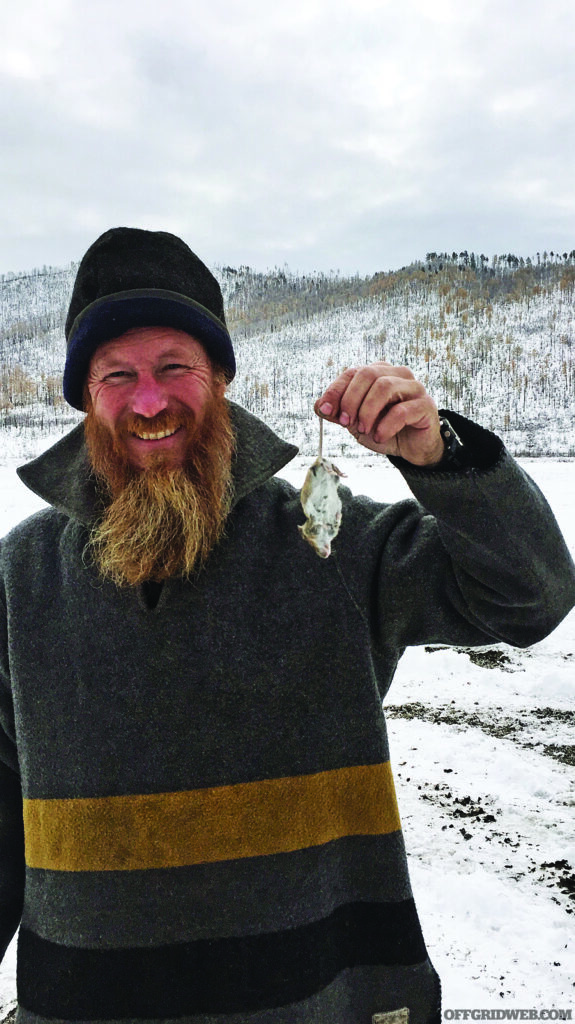 Larry Roberts holding up a successfully hunted mouse.