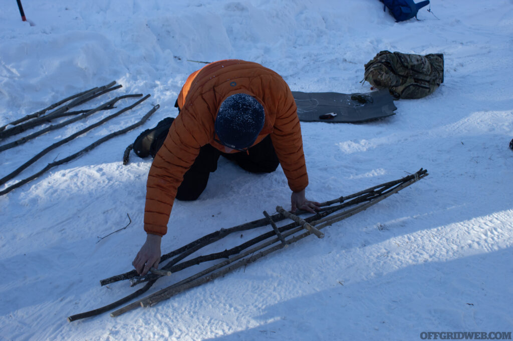 Photo of instructor Jerry Saunders crafting a pair of snowshoes from processed saplings.