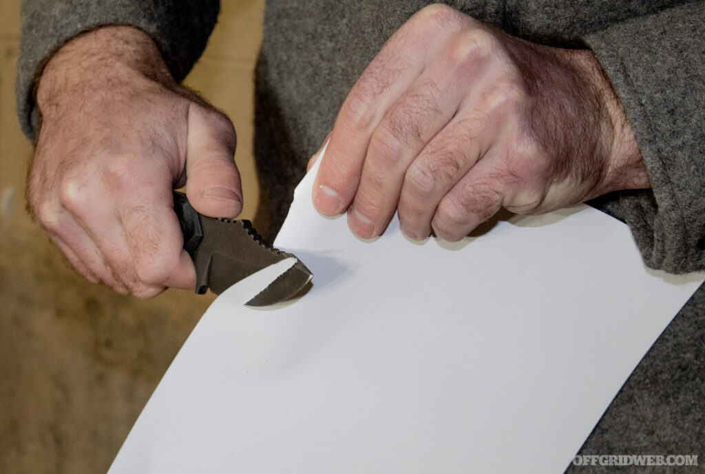 Photo of the POPS MK2 being tested for sharpness by slicing a piece of printer paper.