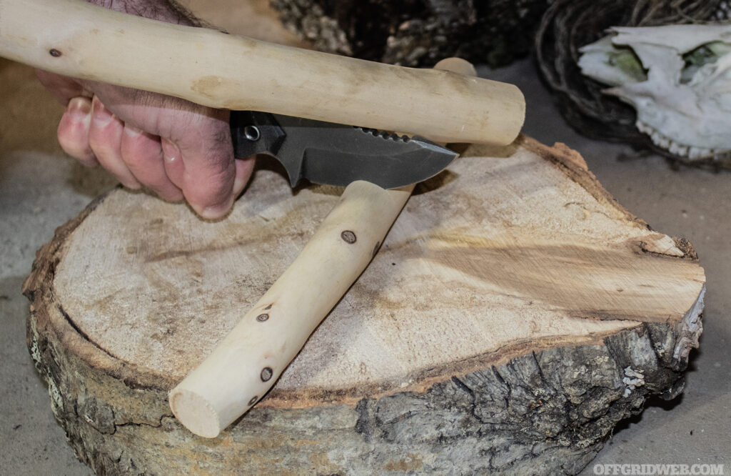 Photo of the POPS MK2 being batoned into a hard chunk of seasoned sugar maple.