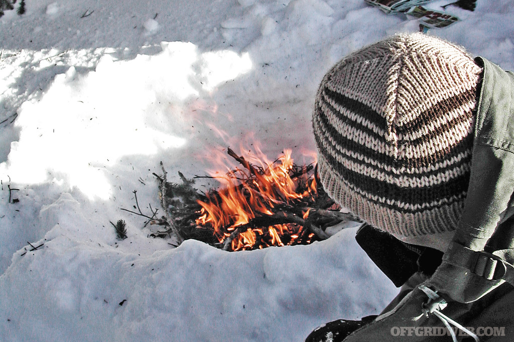 Photo of a small fire burning in the snow.