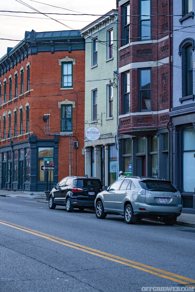 Photo of cars parked near a highway that runs through an urban neighborhood.